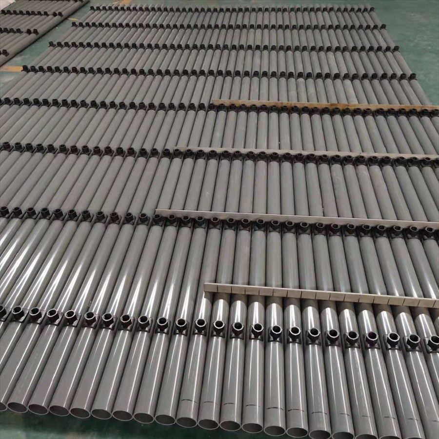 Rows of grey ABS pipe with black fittings at the plant