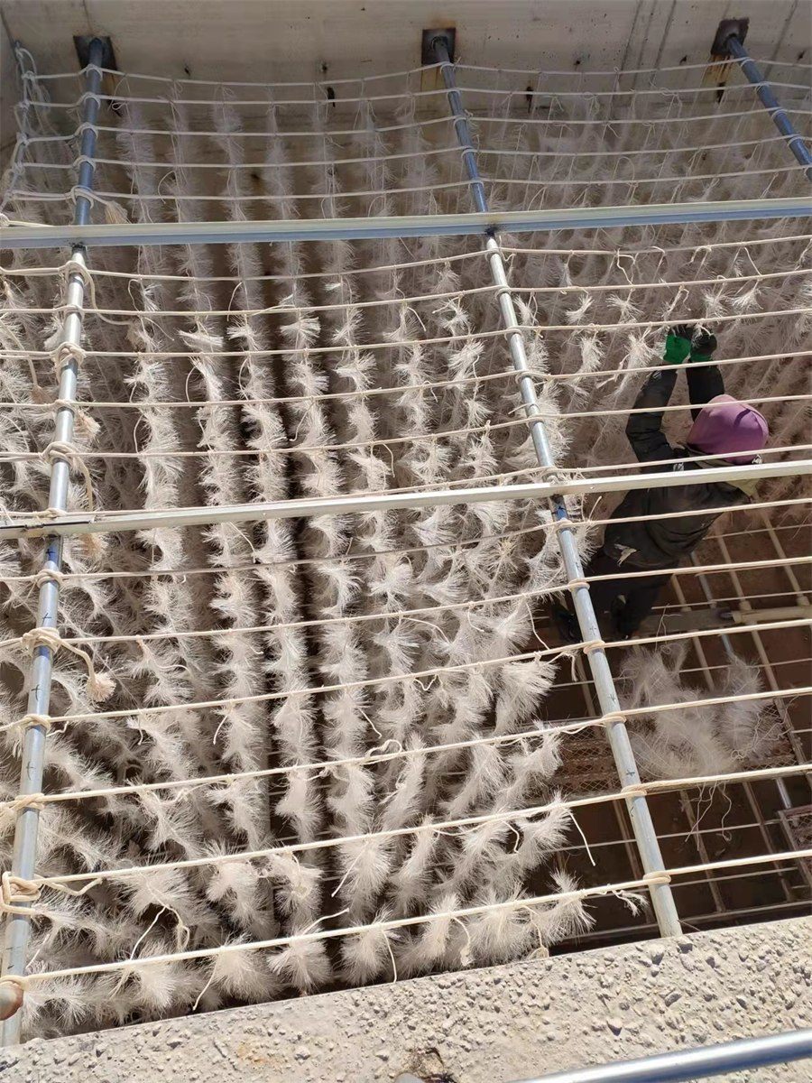 Worker installing elastic packing strands in a tank