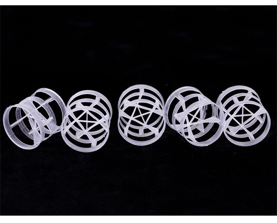 Row of five semi-transparent polypropylene Pall rings on a black background