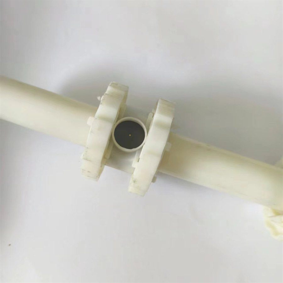 Aerator body with a black membrane disc between two toothed clamp rings, white background