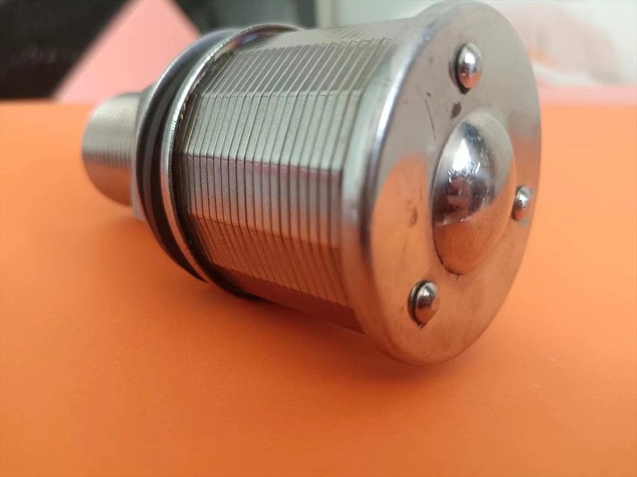 Close-up of the wedge-wire slotted cylinder and domed cap of a drain cap