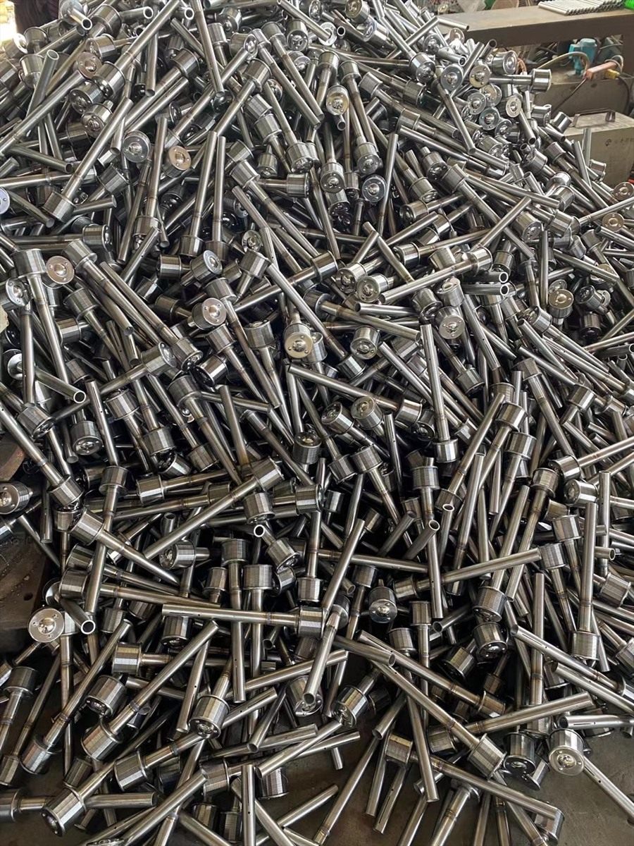 Long-handle drain caps piled in bulk after machining